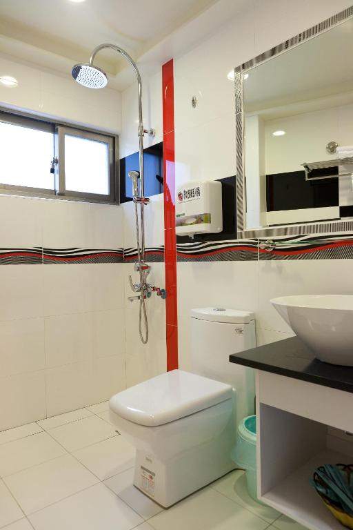 a bathroom with a shower and a toilet and a sink at Ibizakenting Hotel in Kenting