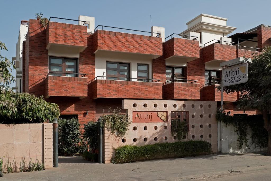 ein rotes Backsteingebäude mit einem Zaun davor in der Unterkunft Atithi Guest House in Jaipur