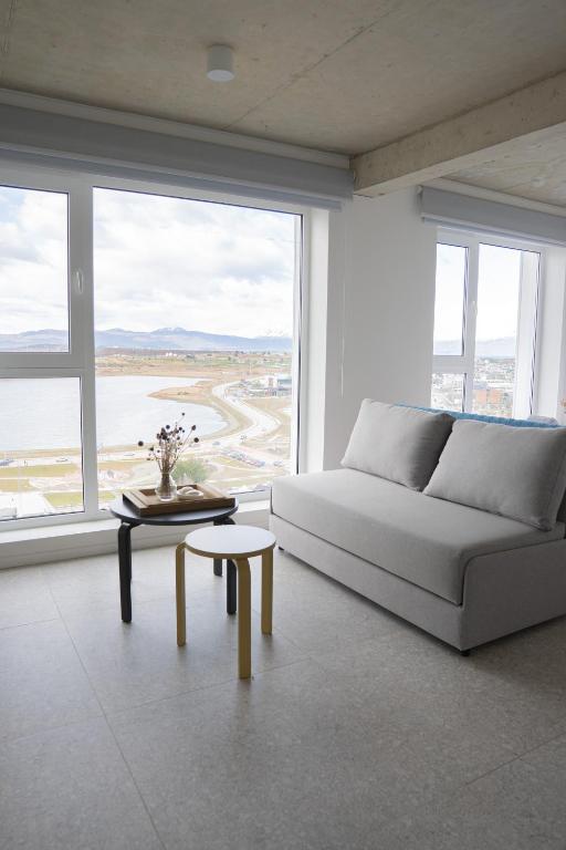a white living room with a couch and a table at Casa Cima in Ushuaia