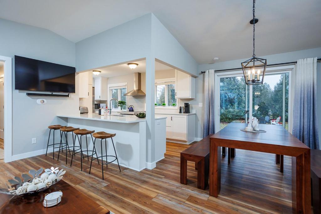 eine Küche und ein Wohnzimmer mit Tisch und ein Esszimmer in der Unterkunft Marina Cottage by Simple Life Rentals in Baileys Harbor