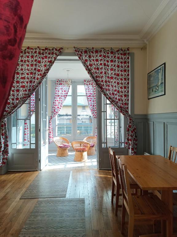 une salle à manger avec une table et des chaises et une vue sur un patio dans l'établissement Villa mexiquaine, à Barcelonnette