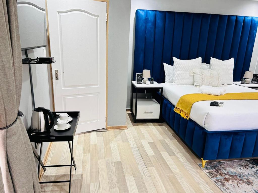 a bed with a blue headboard in a room at The greenary guest house and restaurant in Thohoyandou