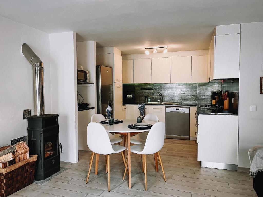 y cocina con mesa, sillas y fogones. en Casinha Praia Azul, en Costa de Lavos