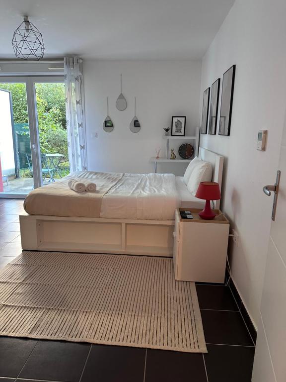 - une chambre avec un grand lit et une lampe rouge dans l'établissement Nina-Studio, à Strasbourg