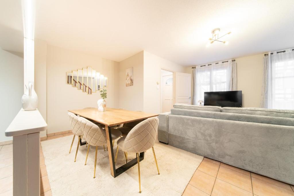 une salle à manger avec une table et un canapé dans l'établissement Le Grand Lion Colmar Centre Parking Gratuit, à Colmar