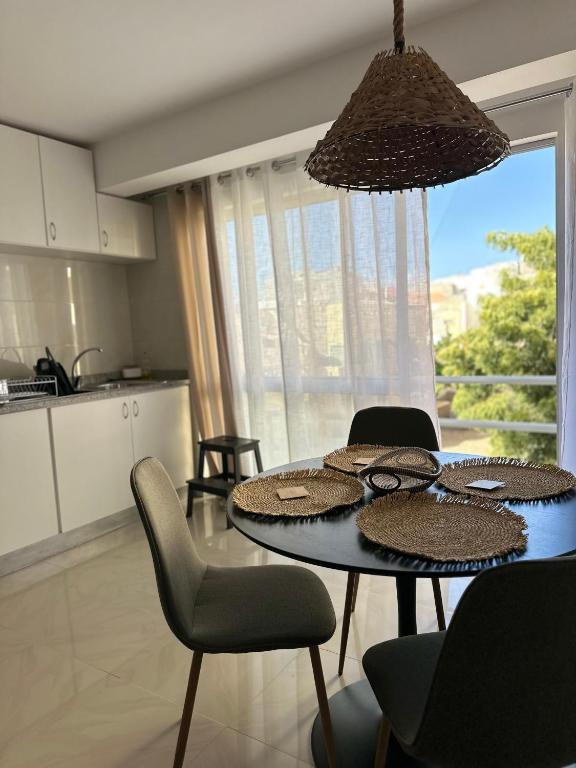 a kitchen with a dining table with chairs and a tableablish at T2 Centro cidade in Mindelo