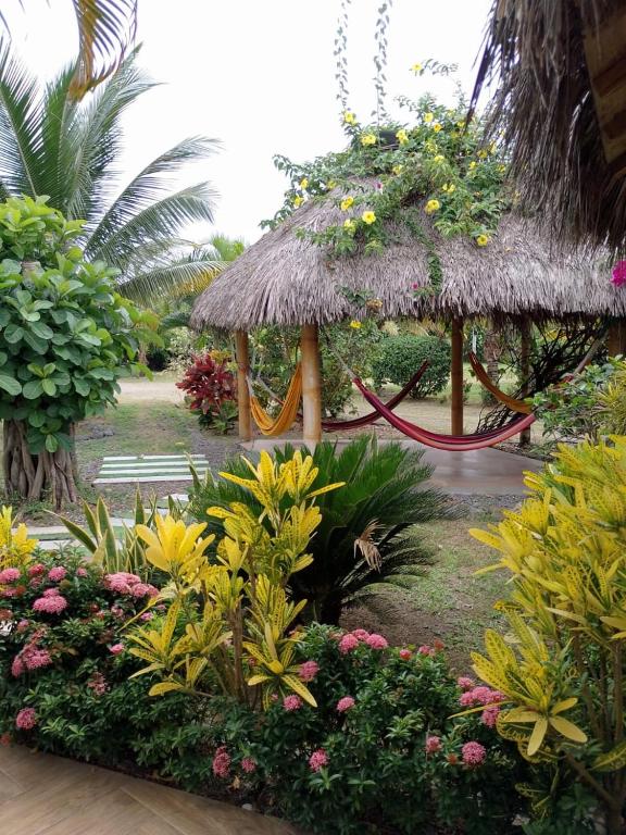 a garden with a playground with a swing and flowers at Cabañas Riviera Pacific in Pedernales