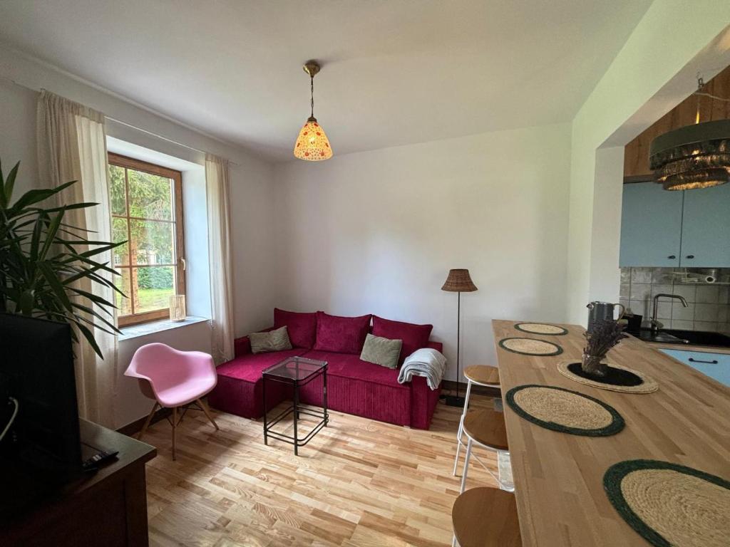a living room with a red couch and a table at Pastelowa Czantoria in Ustroń