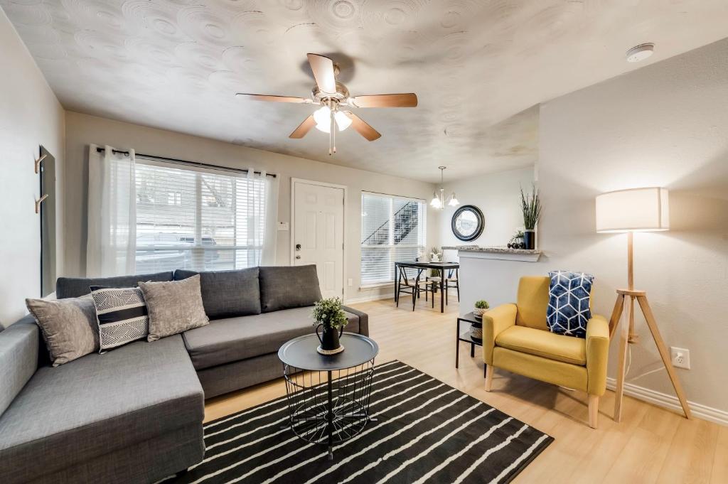 a living room with a couch and a ceiling fan at Global Cup Insta-Worthy Flat and Arboretum Tickets Included in Dallas