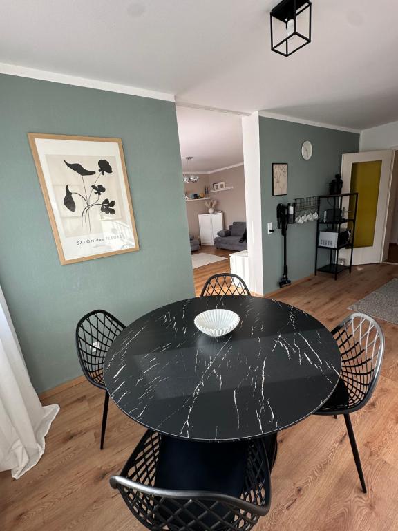 a dining room with a black table and chairs at Familienfreundliche FEWO in bester Lage in Offenburg