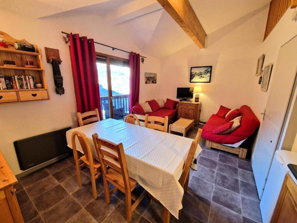 une salle à manger avec une table et des chaises rouges dans l'établissement Résidence Grand Argentier - 2 pièces + mezzanine 6/8 personnes 53m² MAE-2900, à Modane