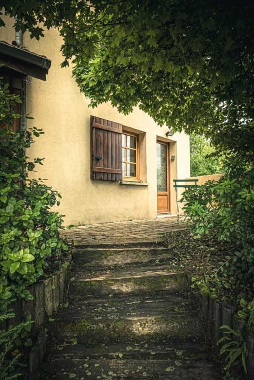 a house with a window and stairs leading to a door at Le Grangeon in Belley