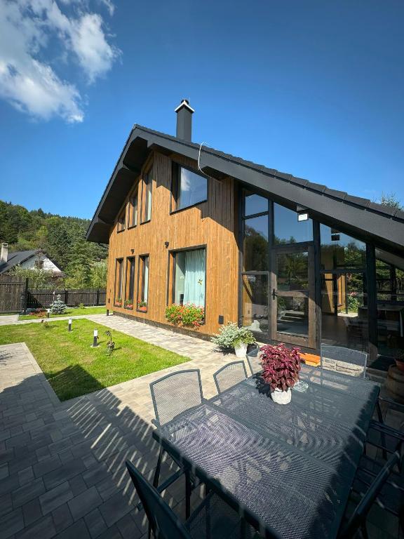 a house with a table and chairs on a patio at Chata pod Cigerníkom in Matiašovce