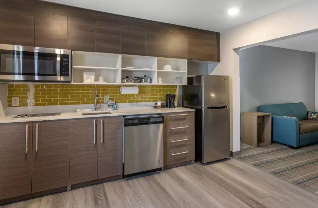a kitchen with wooden cabinets and stainless steel appliances at MainStay Suites Lebanon - Nashville Area in Lebanon