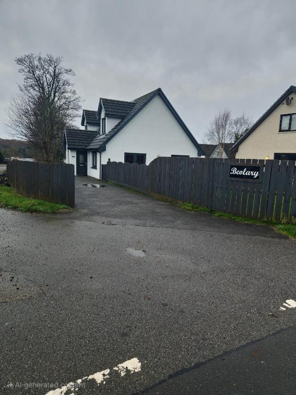 a house with a fence in front of a driveway at Beolary in Oban
