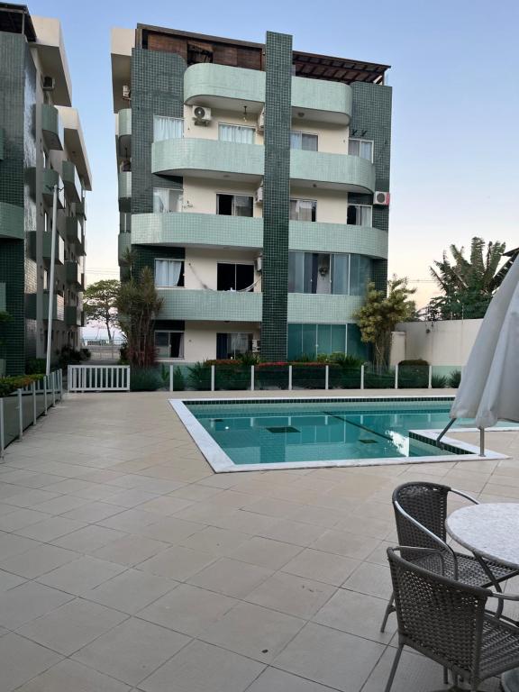 a building with a swimming pool in front of a building at Pé na areia in Ilhéus