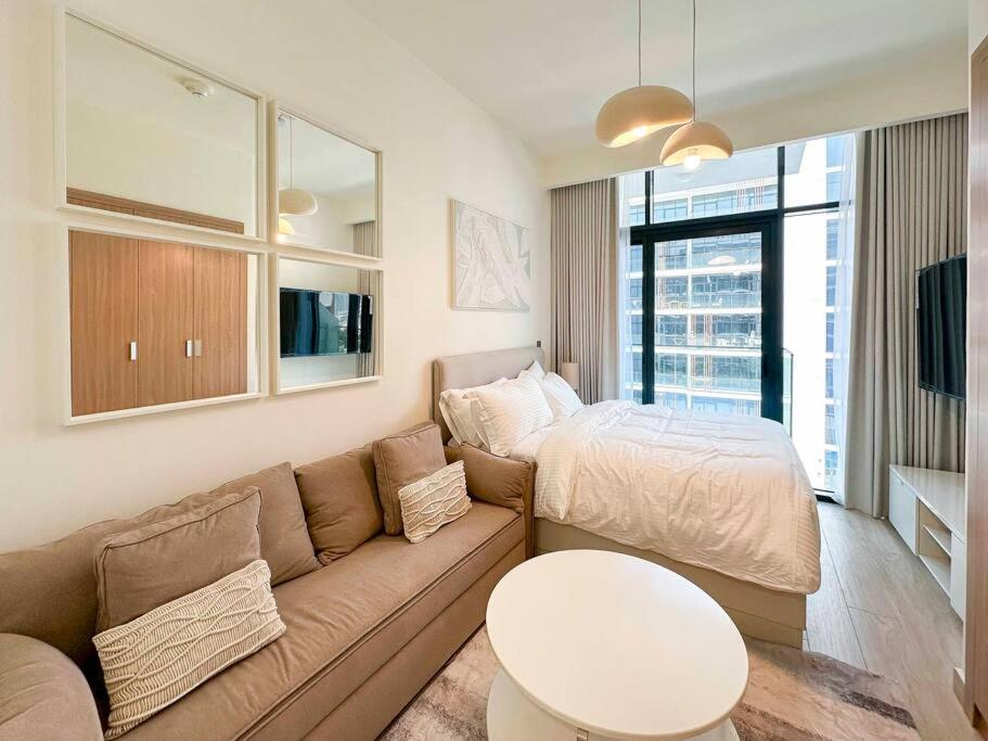 un salon avec un canapé et un lit dans l'établissement Luxury Studio near burj khalifa in Azizi Riviera, à Dubaï