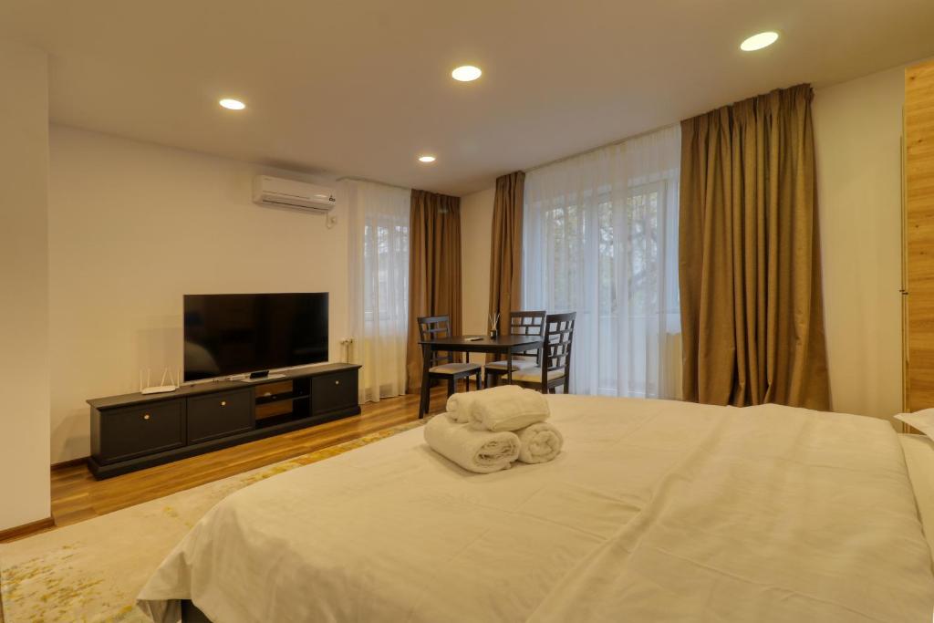 a bedroom with a bed with a television and a table at 2 Hidden Gems - all U need - by Uni88 Apart Hotel in Bucharest