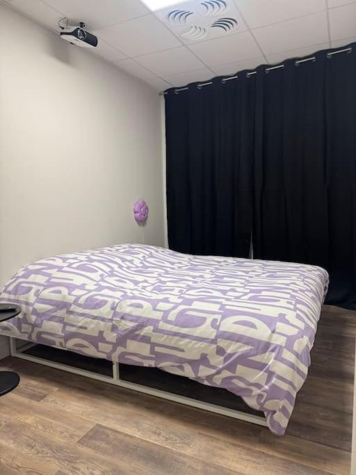 - une chambre avec un lit doté d'une couette violette et blanche dans l'établissement Chambre indépendante, à Muret