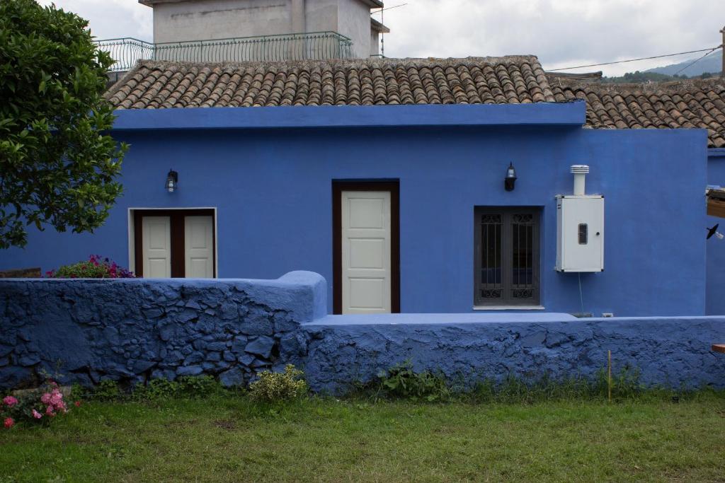 ein blaues Haus mit einer Steinmauer in der Unterkunft Casa Macchia in Giarre