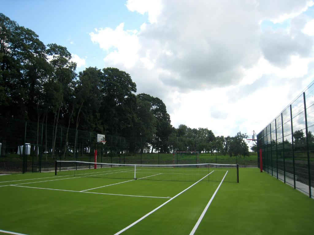 a tennis court with two tennis nets on it at Bistrampolis Manor in Kučiai