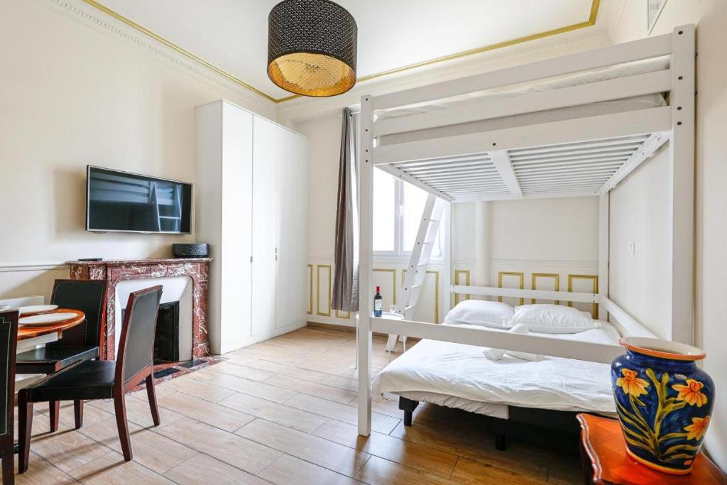 - une chambre avec des lits superposés et une salle à manger dans l'établissement Élégante Suite Haussmannienne au coeur du 6ème, à Paris