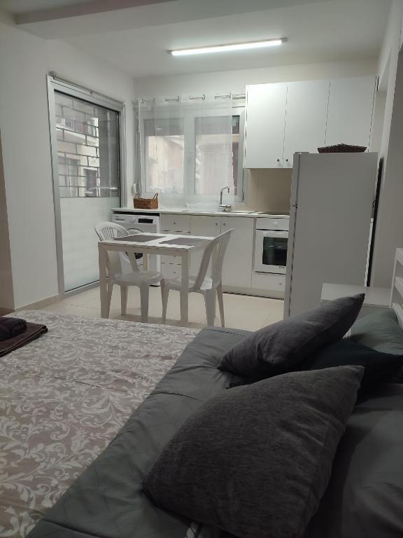a bedroom with a bed and a kitchen with a table at Alkinoos Studio in Nicosia