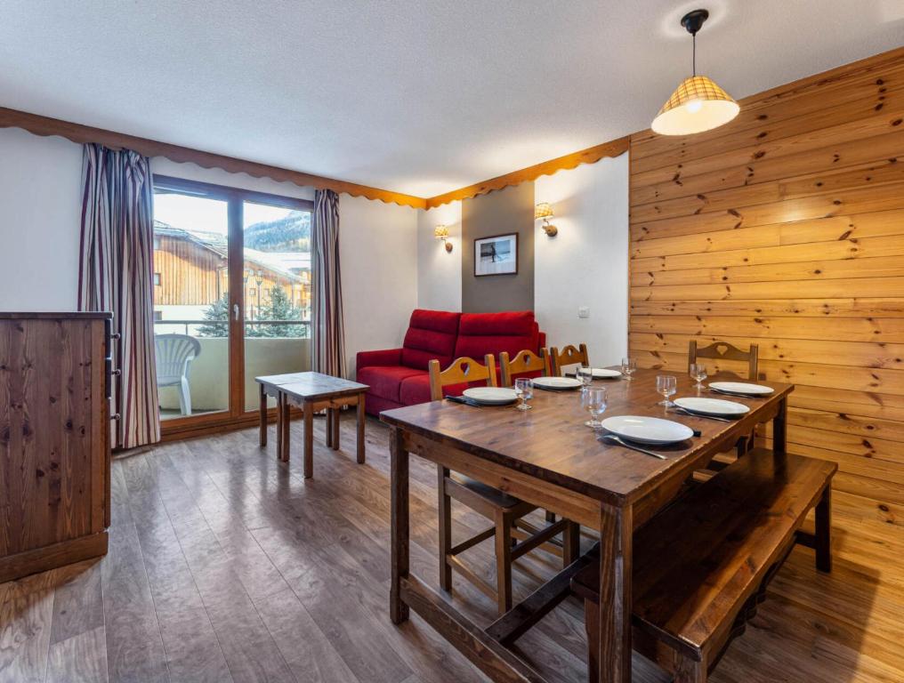 un salon avec une table et un canapé rouge dans l'établissement Résidence Les Hauts De Preclaux - Appartement de montagne pour 8 personnes MAE-3691, aux Orres