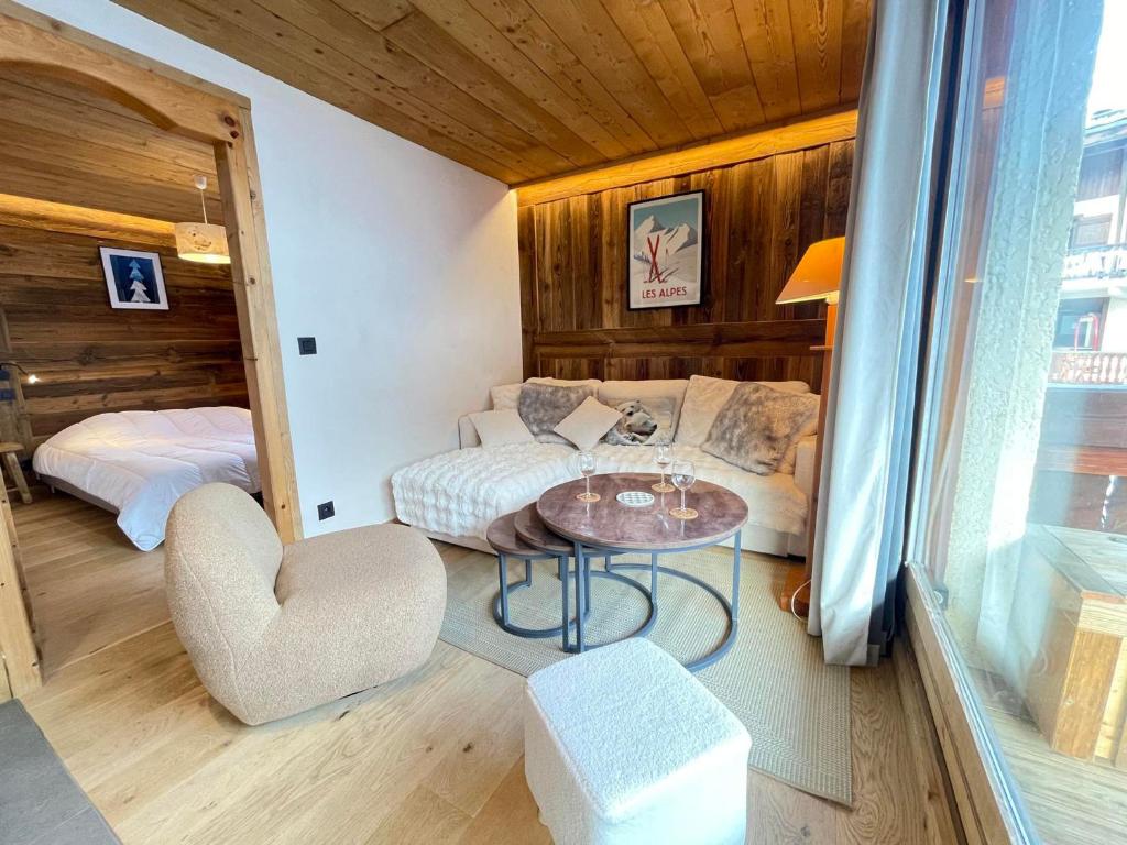 Cette chambre comprend un canapé, une table et un lit. dans l'établissement Charmant appartement au pied des pistes avec WIFI à Notre-Dame-de-Bellecombe - FR-1-505-180, à Notre-Dame-de-Bellecombe