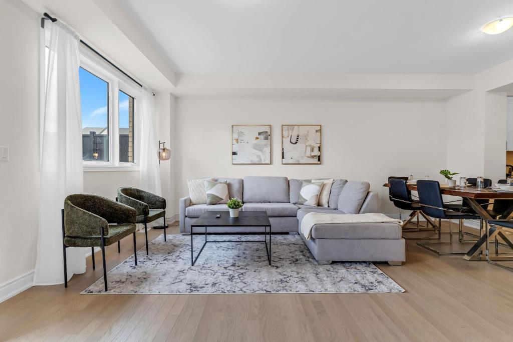 ein Wohnzimmer mit Sofa und Tisch in der Unterkunft Bright & Stylish Modern Townhome in Oakville! in Oakville