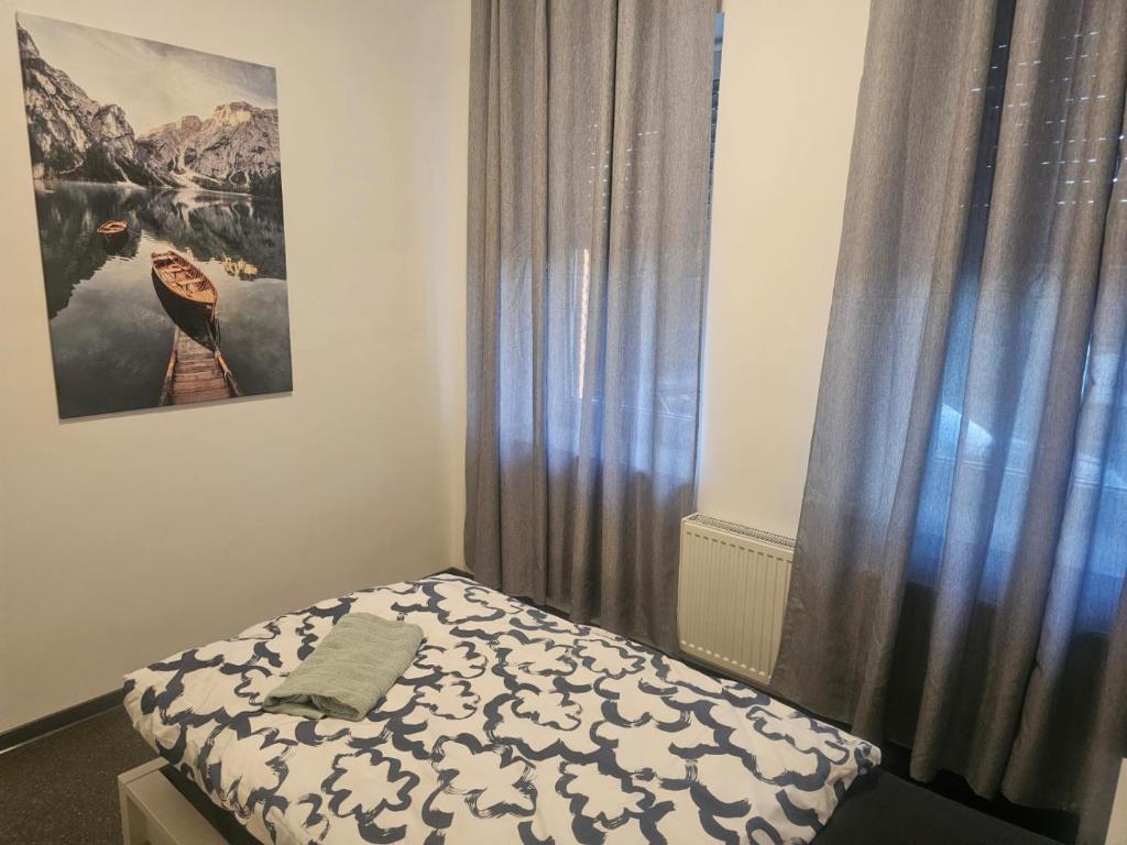 a small bedroom with a bed and a curtain at Work and Stay Eschweiler 50qm 2 Betten Küche und Badezimmer in Eschweiler