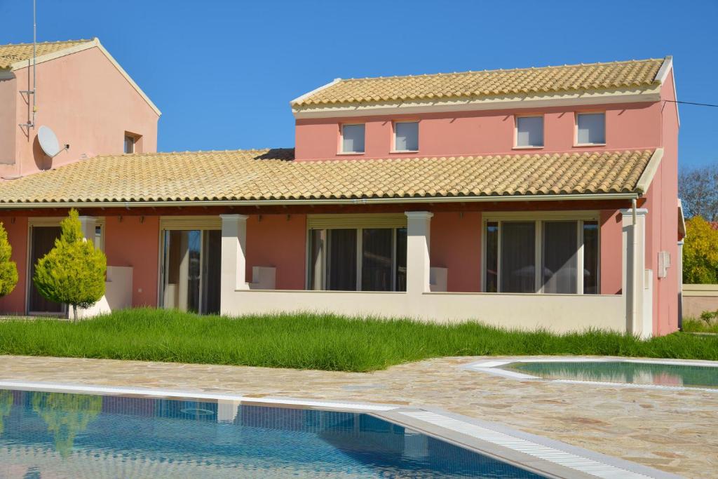 a house with a swimming pool in front of it at Megali Luxuries Apartments in Sidari
