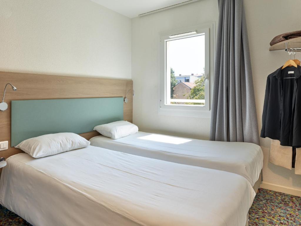 Postel nebo postele na pokoji v ubytování Hôtel REVOTEL Nancy Centre Gare et Congrès