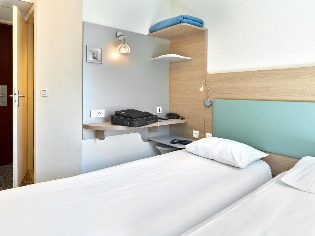 Postel nebo postele na pokoji v ubytování Hôtel REVOTEL Nancy Centre Gare et Congrès