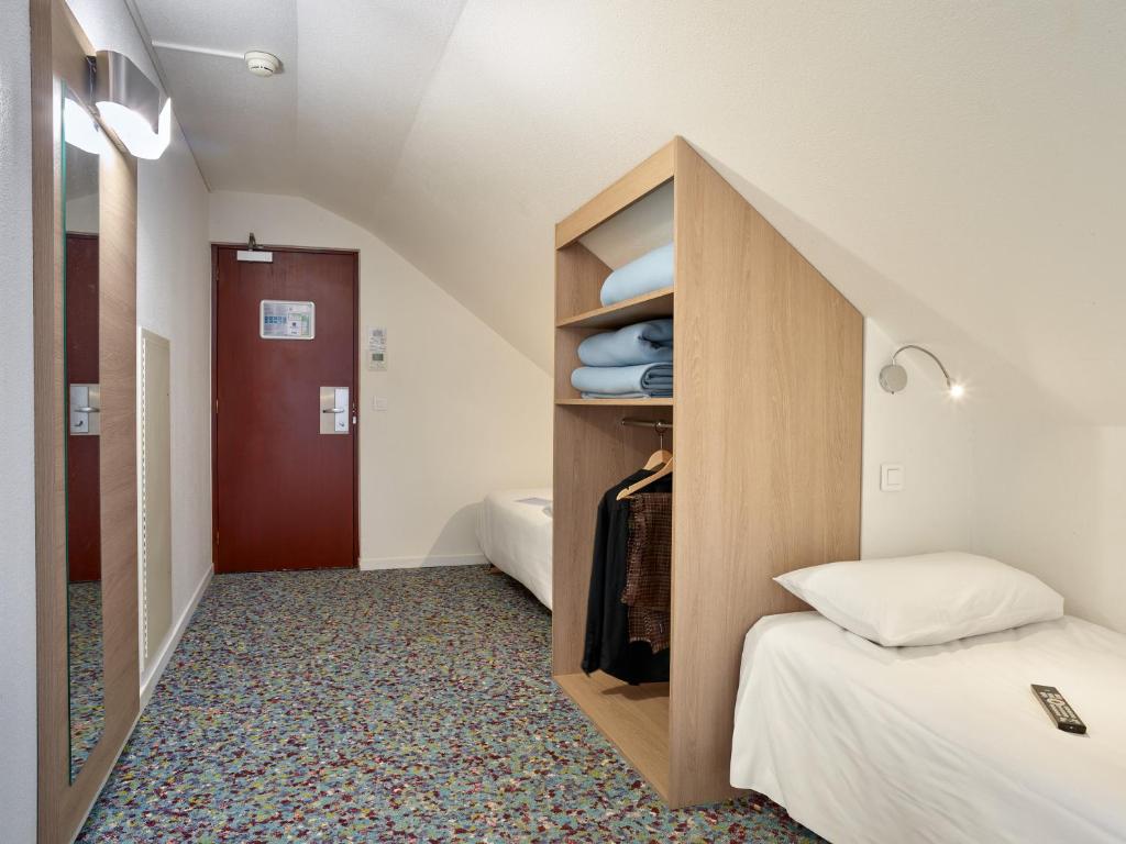 Postel nebo postele na pokoji v ubytování Hôtel REVOTEL Nancy Centre Gare et Congrès