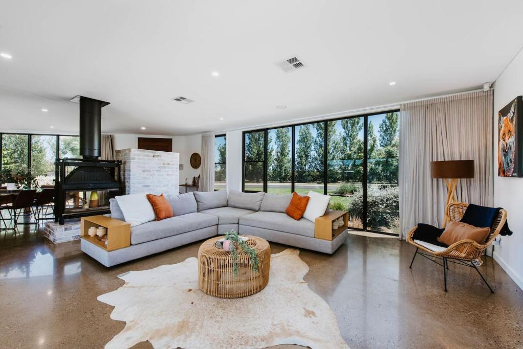 a living room with a couch and a table at The Wine Manor - Lavish Poolside Living in Mudgee
