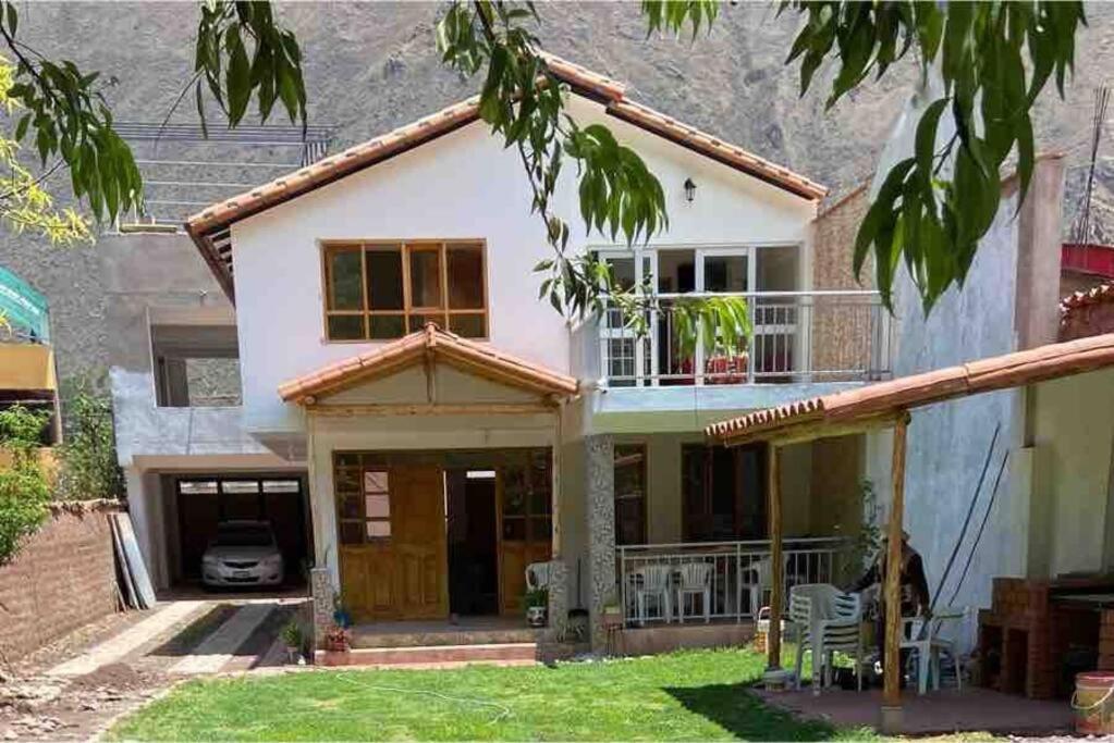 a house with a porch and a balcony at La casa del bosque CALCA in Pisac