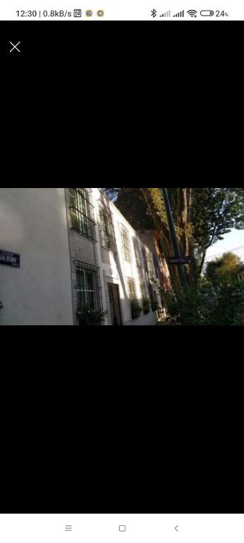 a picture of a building with a tree in front of it at Flamingo 38 en SúperAnfitrión Coyoacán in Mexico City