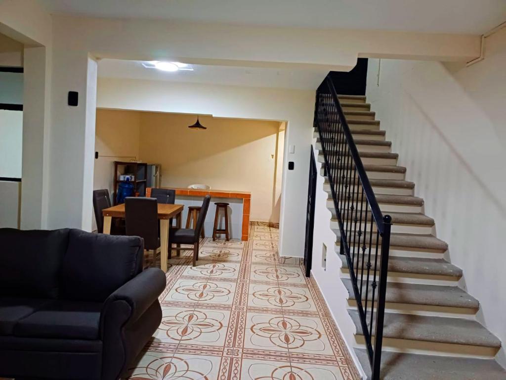 a living room with a staircase with a couch and a table at Casa Victoria in San Cristóbal de Las Casas