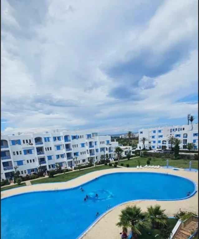 a large swimming pool in front of a building at Marinasmir Jawhara in Fnidek