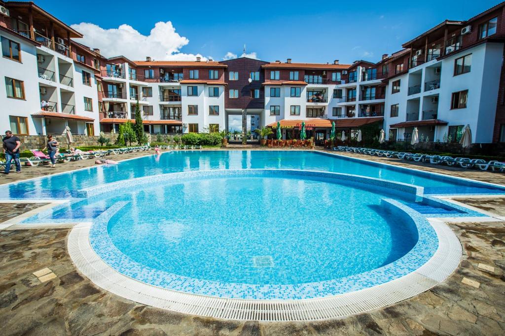 a large swimming pool in front of some apartment buildings at Family hotel Apolon in Nesebar