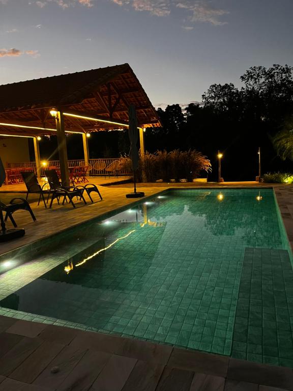 a swimming pool at night with a pavilion at Pousada Vila da Mata - Canastra in São João Batista do Glória