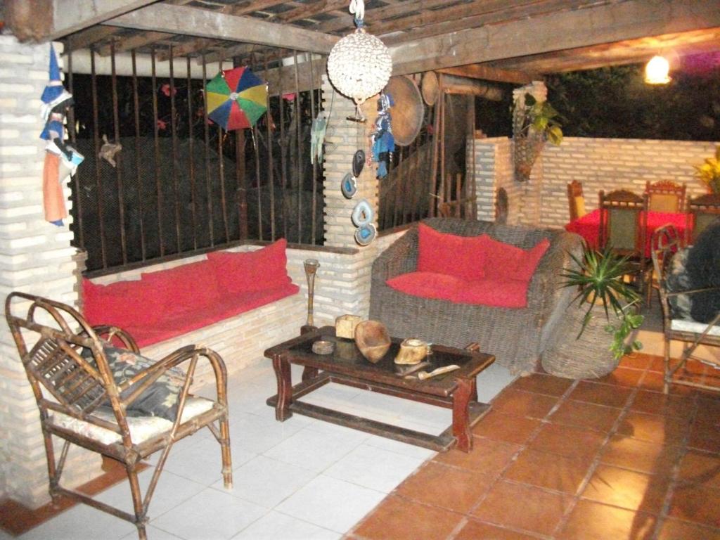 a patio with a couch and a table and chairs at Pousada Villa Amari in Armação do Tairu