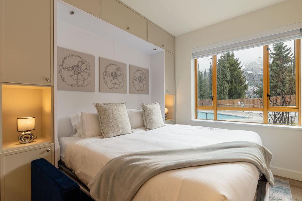 a bedroom with a large bed and a large window at Newly Renovated KING BED STUDIO in the Village in Whistler