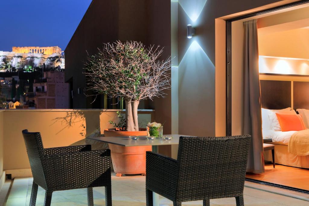 a room with a table and chairs and a bedroom at O&B Athens Boutique Hotel in Athens