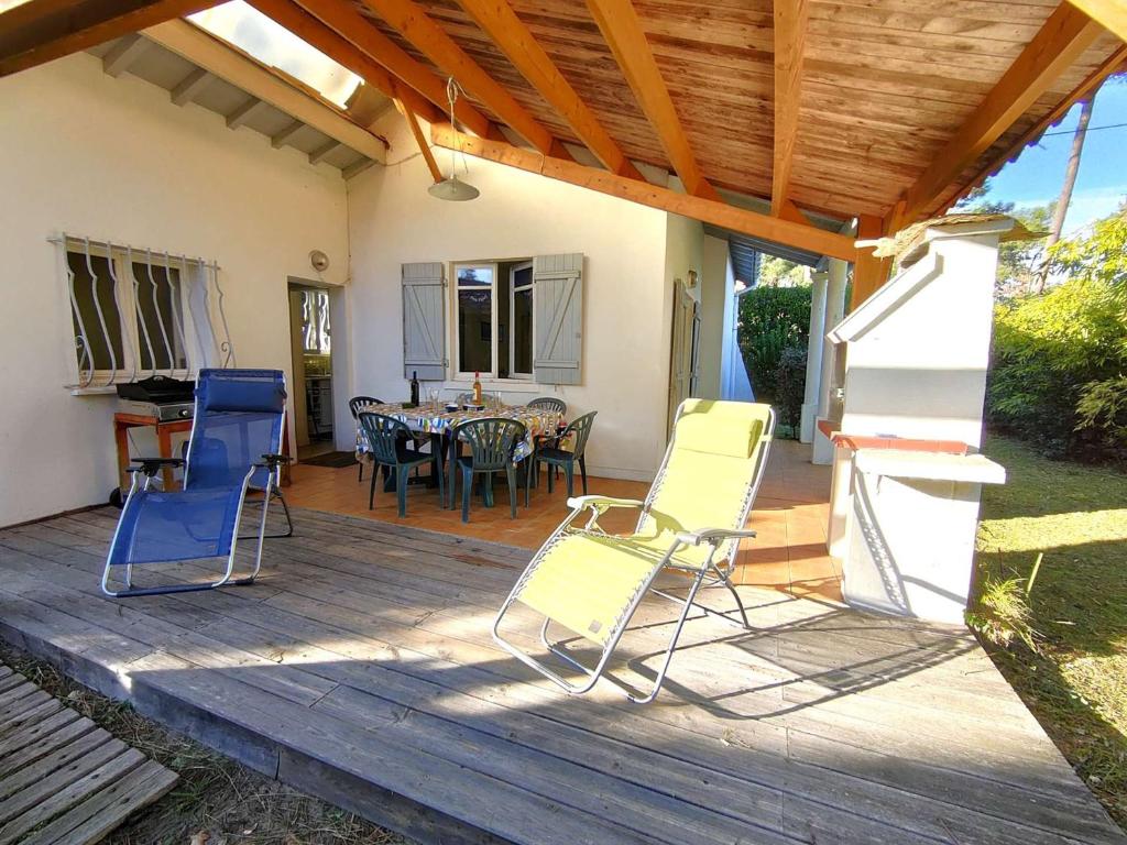 un patio avec des chaises et une table sur une terrasse dans l'établissement Charmante villa à Petit-Piquey avec Jardin et WIFI, Proche Commodités - FR-1-736-49, à Lège-Cap-Ferret