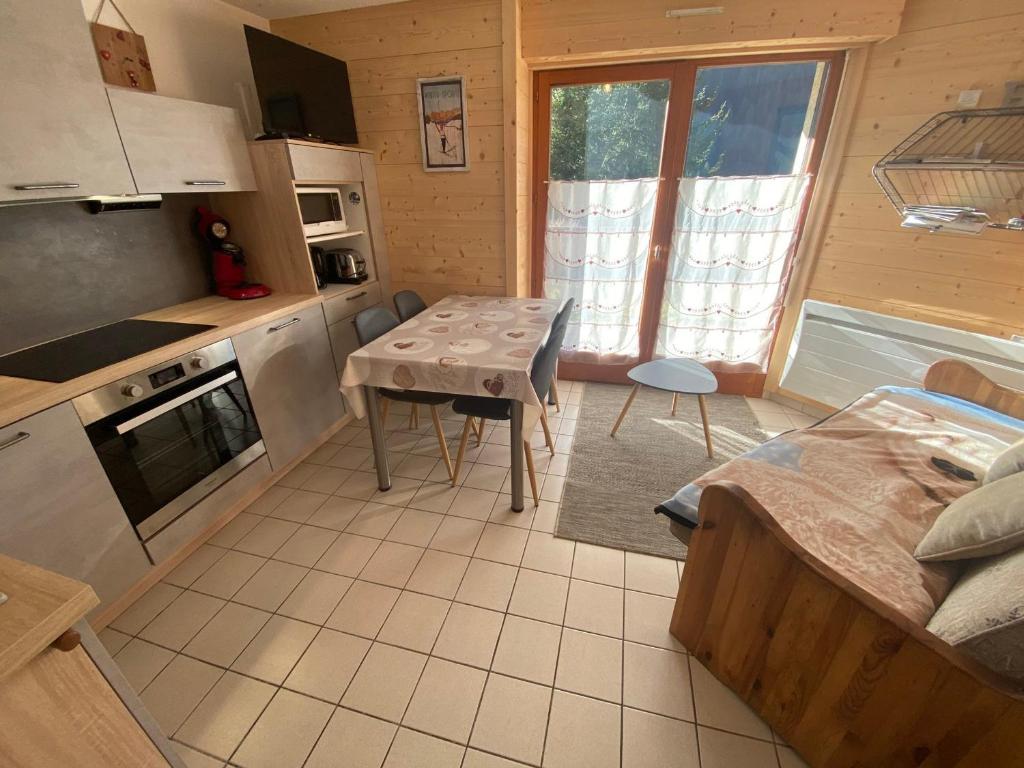une cuisine avec une petite table et une cuisine avec une table dans l'établissement Charmant appartement à Châtel, 4 pers, parking privé, terrasse, proche centre - FR-1-693-115, à Châtel