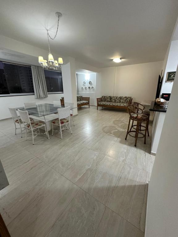 a living room and dining room with a table and chairs at Apartamento maravilhoso na Pitangueiras Guarujá in Guarujá