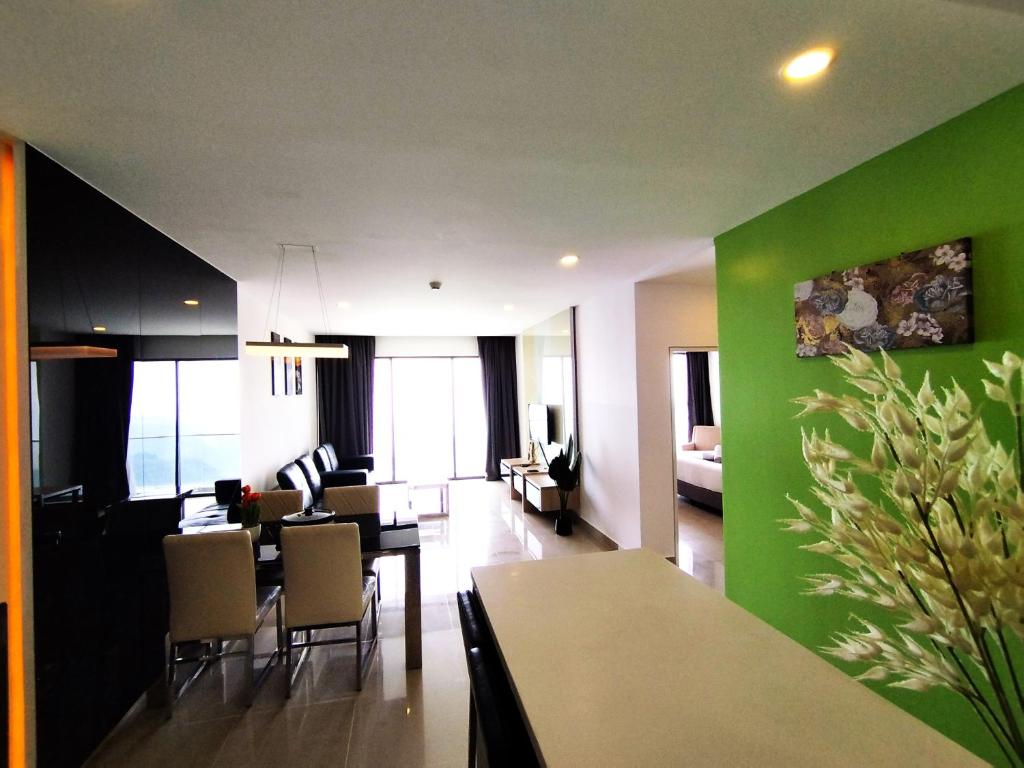 un soggiorno con tavolo e parete verde di Genting SkyFoggyColdInn2R2B AT Ion Delemen a Resorts World Genting