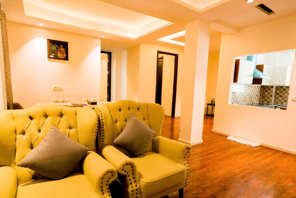 a living room with a yellow couch and a table at Holiday in Homestay in Shimla